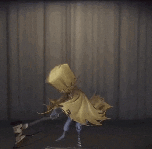 a statue of a person with a yellow cape holding a hammer