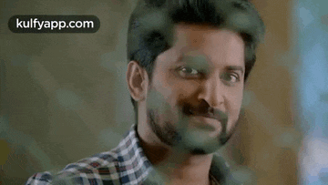 a man with a beard is smiling with his eyes closed in a close up of his face .