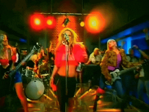 a woman singing into a microphone in front of a crowd of people