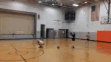 a blurry picture of a basketball court with an american flag in the background