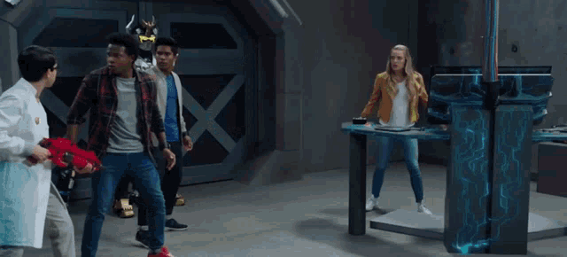 a group of people are standing in a room with a robot in the background