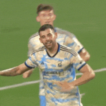 a soccer player in blue shorts is kicking a soccer ball