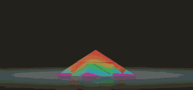 a rainbow colored pyramid is sitting on a dark surface