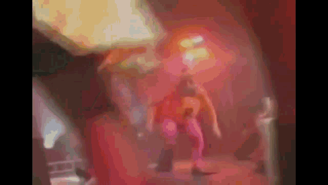 a blurry picture of a person dancing on a stage in a dark room .