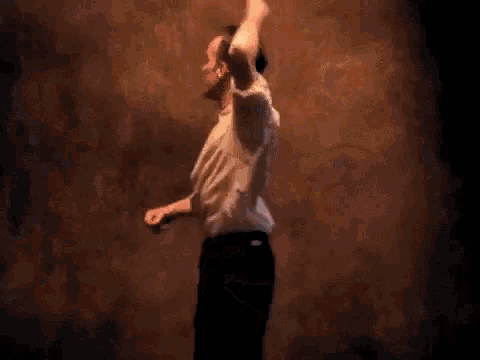 a man in a white shirt and black pants is dancing .