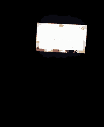 a tv screen shows a picture of a room with a yellow sticker on the bottom right