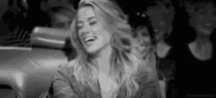 a woman is laughing in a black and white photo .