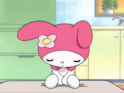 a cartoon character with a flower on her head is sitting on a table with her eyes closed .