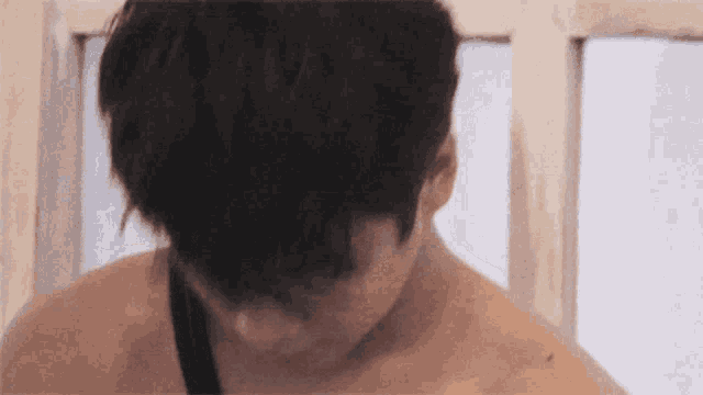 a close up of a person 's head and neck with a window in the background .