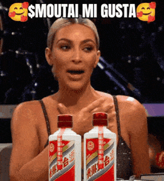 kim kardashian is holding two bottles of alcohol in front of her face .