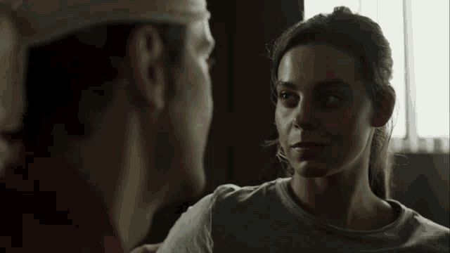 a woman with a bandage on her head looks at a man