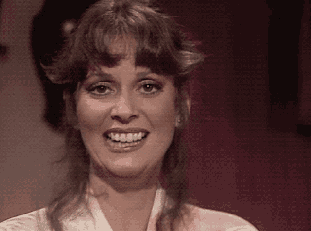 a close up of a woman smiling with a red background