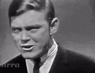 a black and white photo of a man in a suit and tie with nra written in the corner