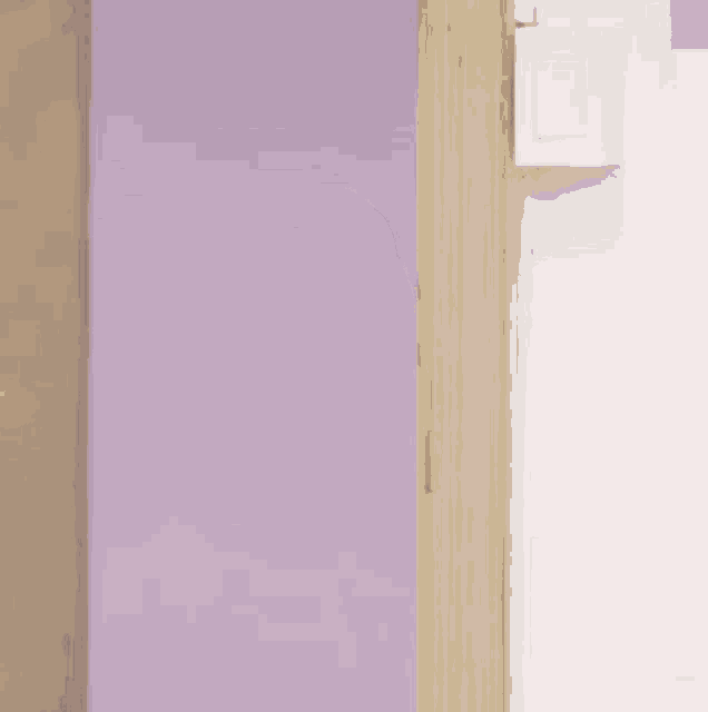 a young man is peeking out of a doorway .