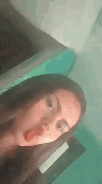 a young woman is taking a selfie with her tongue out .