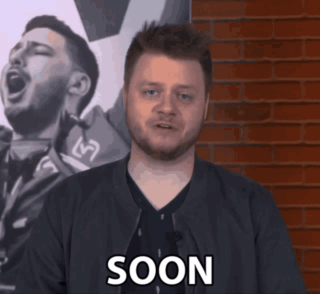 a man says soon in front of a picture of a man