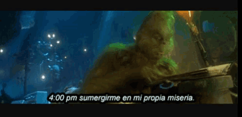 a screen shows a grinch saying 4:00 pm sumergime en mi propia miseria