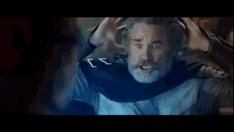 a man with a beard and mustache is holding his head and looking at another man