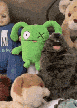 a group of stuffed animals including a green bunny with an x on its head
