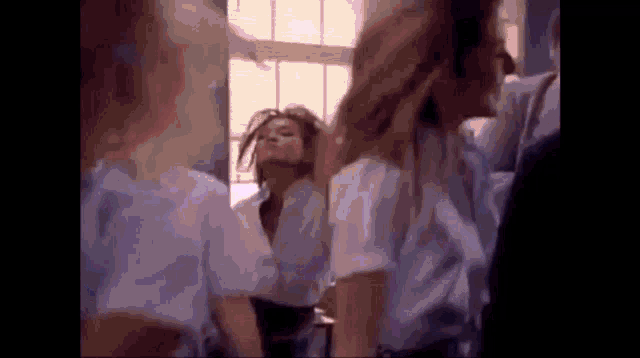 a group of young women are standing in front of a mirror .