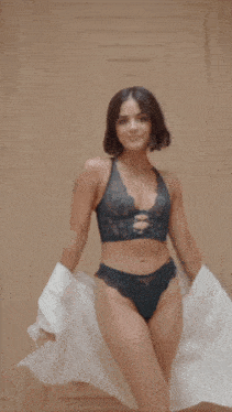 a woman in lingerie is holding a white cloth
