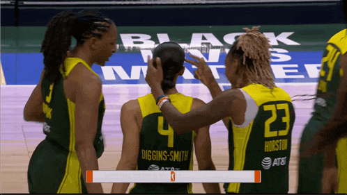 a basketball player with the number 23 on her back talks to another player