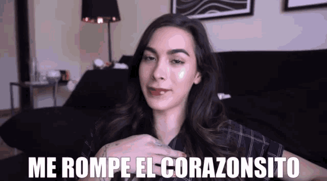 a woman says me rompe el corazonsito while sitting on a black couch