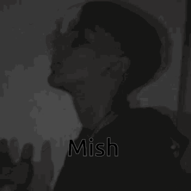 a man is smoking a cigarette in a black and white photo with the word mish written on it .
