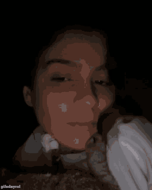 a woman with a nose ring is holding a cat in her lap ..