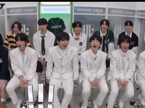 a group of young men are sitting in front of a sign that says " universe league "