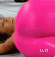 a woman in a pink dress is laying on her stomach on a bed .