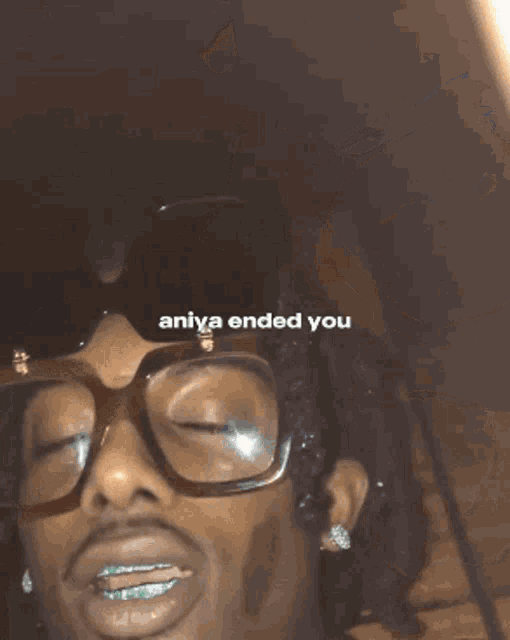 a man wearing glasses is smoking a cigarette with the words " aniya ended you " written on the bottom