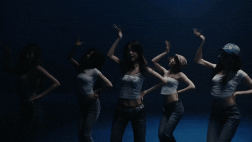 a group of women are dancing in a dark room