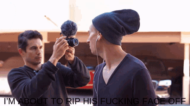 a man taking a picture of another man with the words i 'm about to rip his fucking face off below him