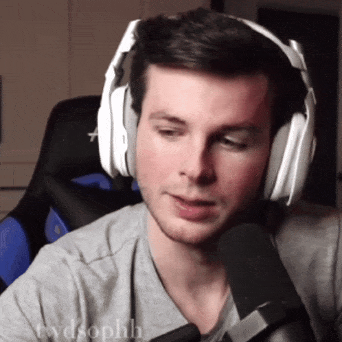 a man wearing headphones and a shirt that says twdsophh is talking into a microphone