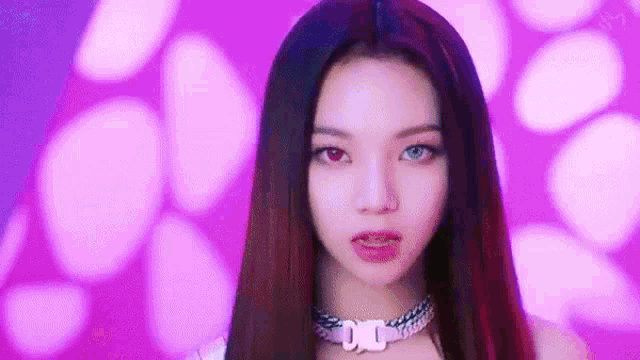 a close up of a woman wearing a choker and red and blue eyes .