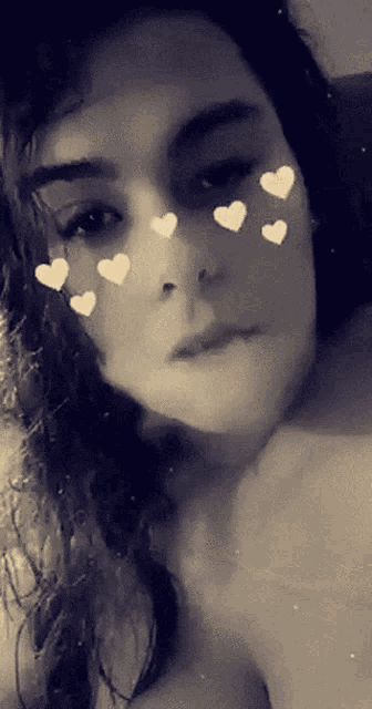 a black and white photo of a woman 's face with hearts on it
