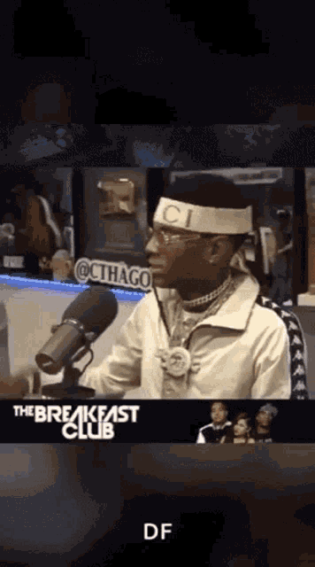 a man wearing a headband with the letter ci on it is talking into a microphone