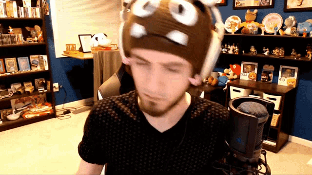 a man wearing headphones and a hat with the letter u on it
