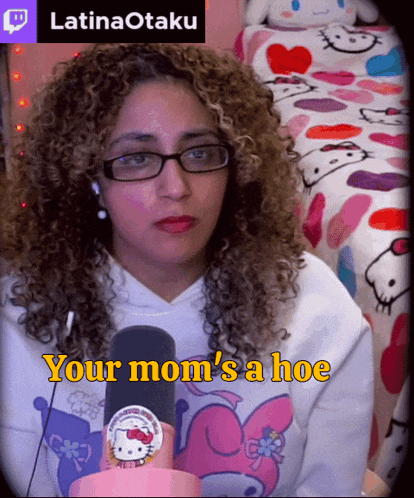 a woman with curly hair wearing glasses and a hello kitty sweatshirt says your mom 's a hoe