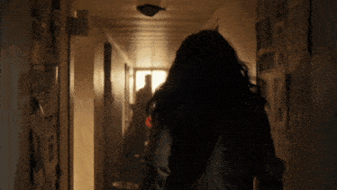 a woman is walking down a hallway with a sign on the wall that says 30
