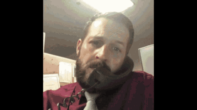 a man with a beard is talking on the phone