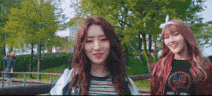 two girls are standing next to each other in a park and one of them is wearing a shirt that says lu vx