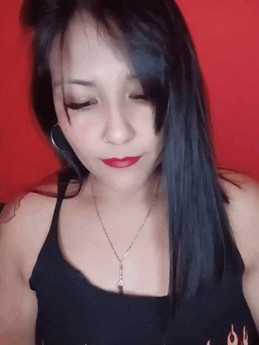a woman wearing a black tank top and a silver necklace