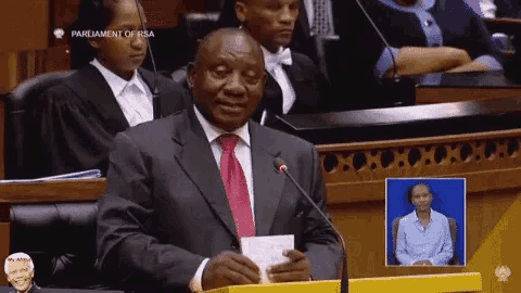 a man in a suit and tie is giving a speech at the parliament