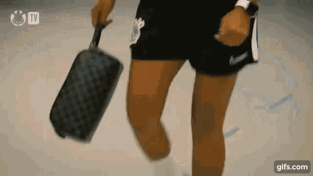 a person is holding a purse in their hand while walking .