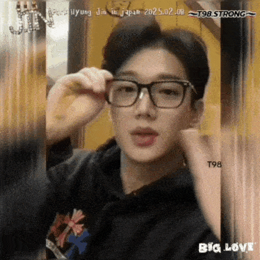 a picture of a young man wearing glasses and a t98 strong sticker