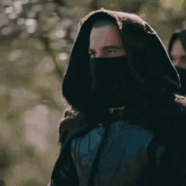 a man is covering his face with his hand and a woman is standing next to him .