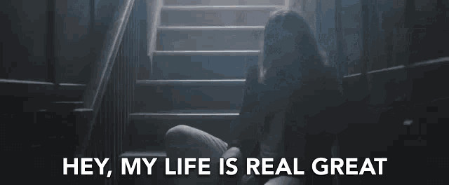 a woman is walking down a set of stairs with the words hey , my life is real great below her