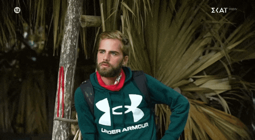 a man in a green under armour hoodie
